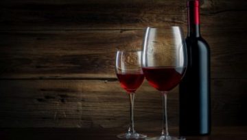 glass and bottle of wine on a wooden background